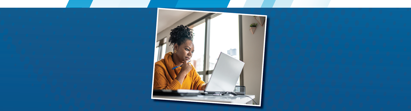 A teacher thoughtfully looking at a laptop and doing work.