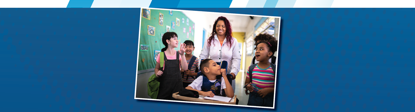 A teacher walking down the hall with four older elementary students