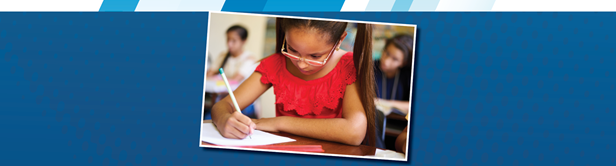 A young student writes at their desk.