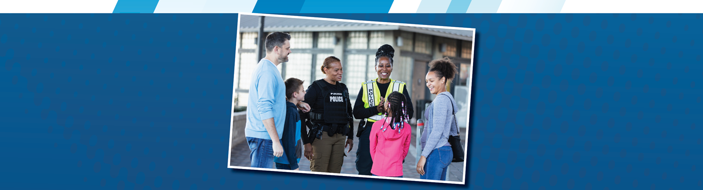 a couple of police officers talking with a couple pairs of parents and students