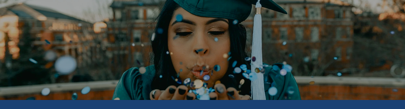 graduate blowing confetti from her hands
