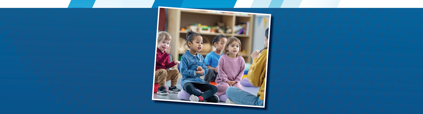a teacher sitting on the floor in front of a preschool class