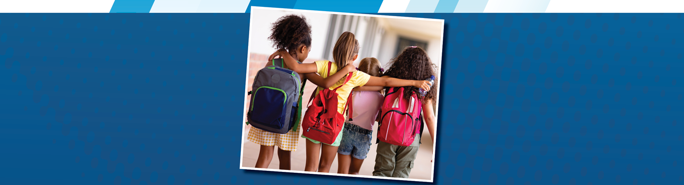 A group of elementary school girls walking down the hall arm in arm