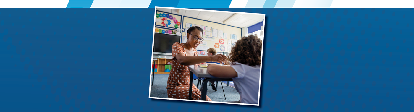 a teacher working with a student at a desk