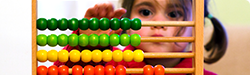 a young girl using a counter with wooden beads
