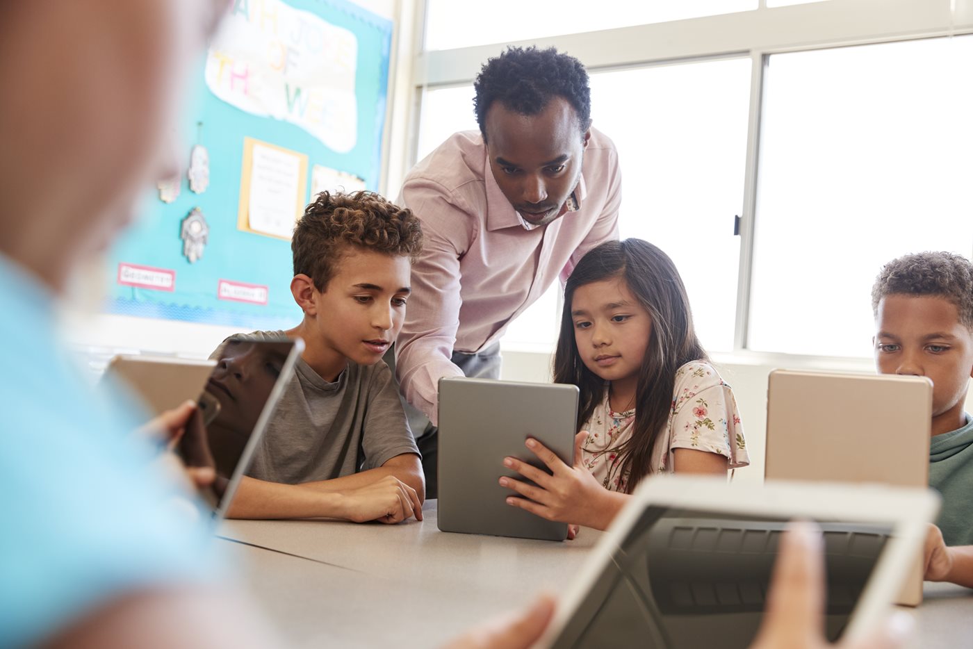 Teacher among school kids using computers