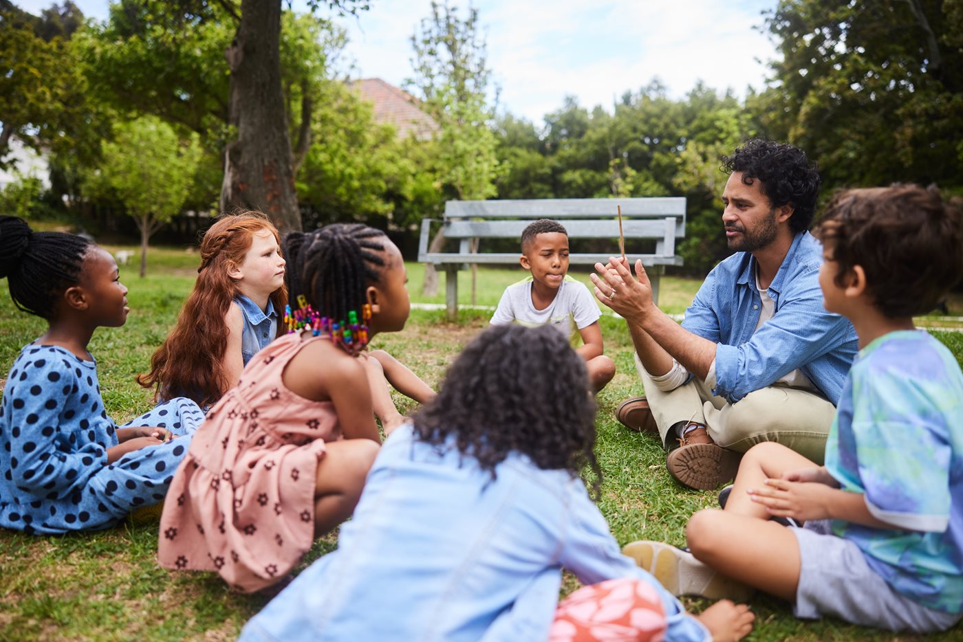 Teacher talking with young students outside