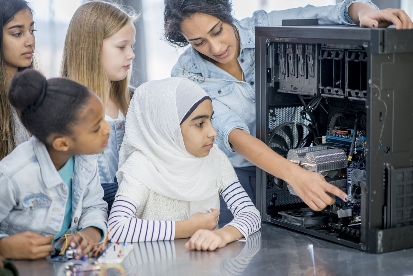 Elementary school children and teacher view inside computer